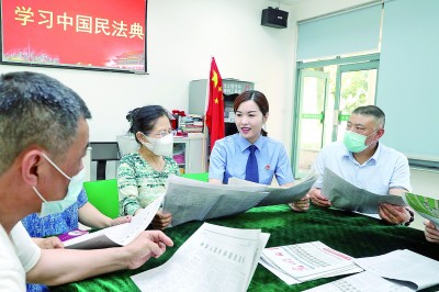 江苏苏州工业园区检察院的检察官在社区辅导居民学习民法典。华雪根摄/光明图片