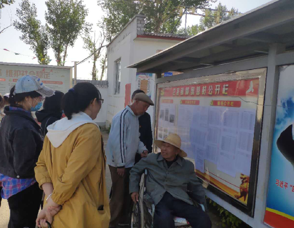 赛罕区巴彦镇郭家营村村民正在“三务”公开栏前了解村务支出情况