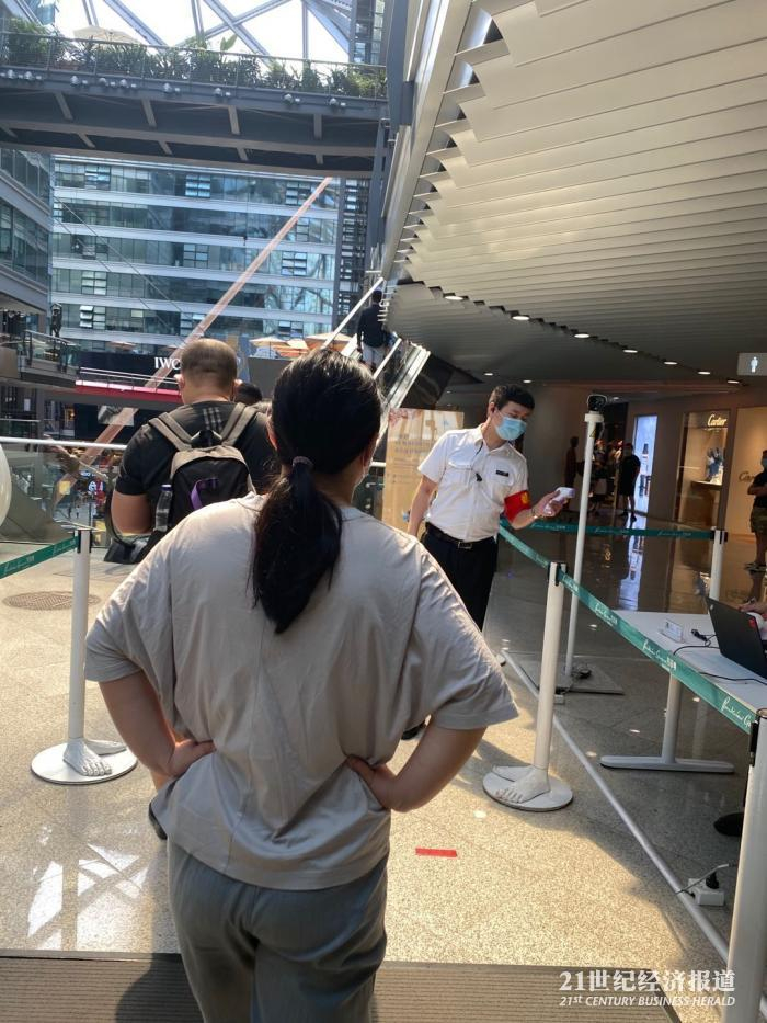 图：6月7日，侨福芳草地商场，顾客进商场排队测体温。摄影：周慧