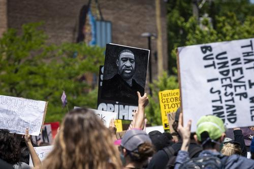  ▲6月6日，示威者手举弗洛伊德的画像在美国芝加哥参加游行示威。 新华社发