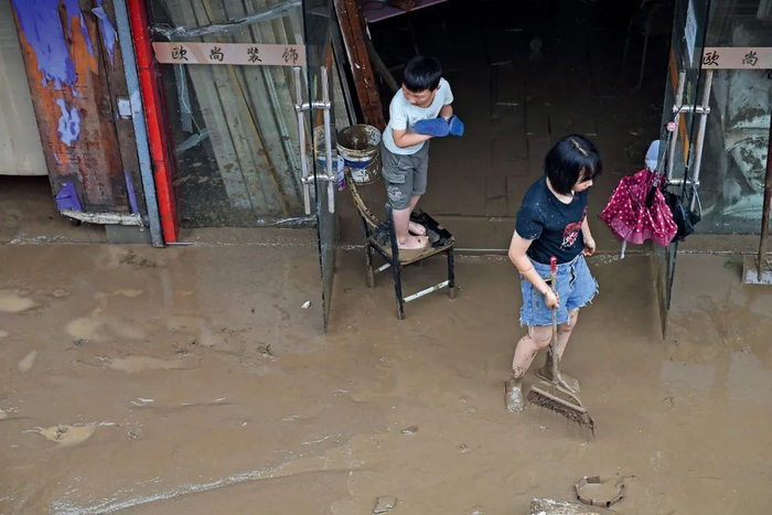 7月7日，歙县的居民在清理淤泥。图/人民视觉