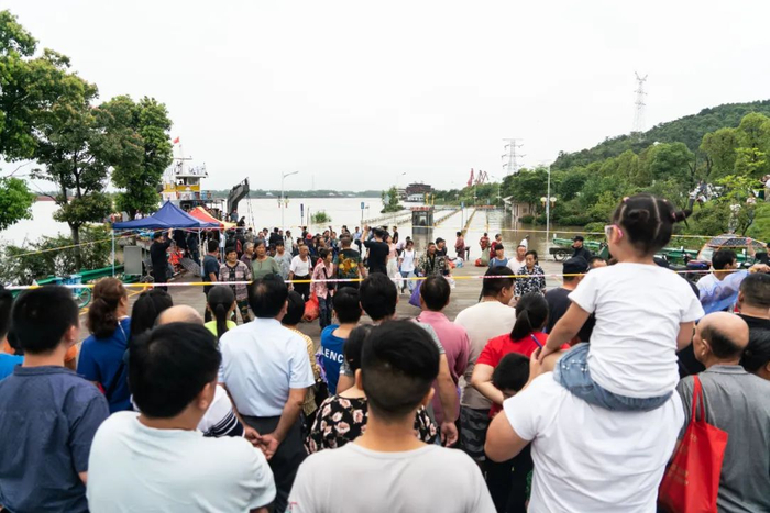 　　在码头等待的人群中除了有来接应的亲戚，还有想看看是否有机会再回一趟江心洲收拾东西的村民。 摄/宛瑾