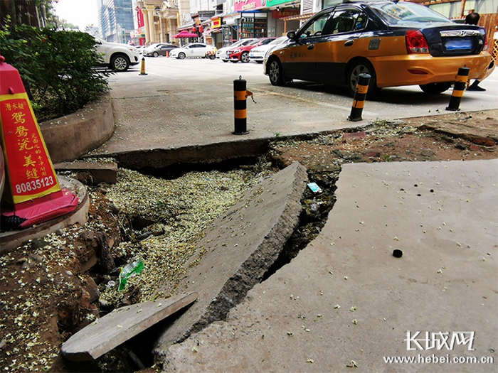 路面塌陷，水泥地面出现断裂。长城新媒体记者 周亚彬 摄