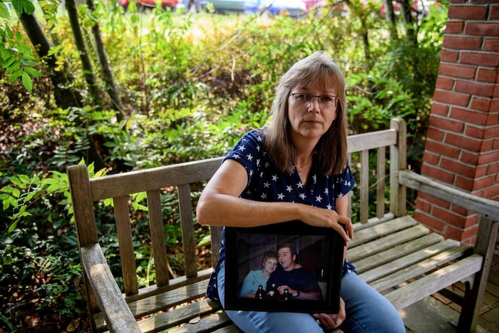 ▲梅兰妮拿着父亲和母亲合影。图据华盛顿邮报