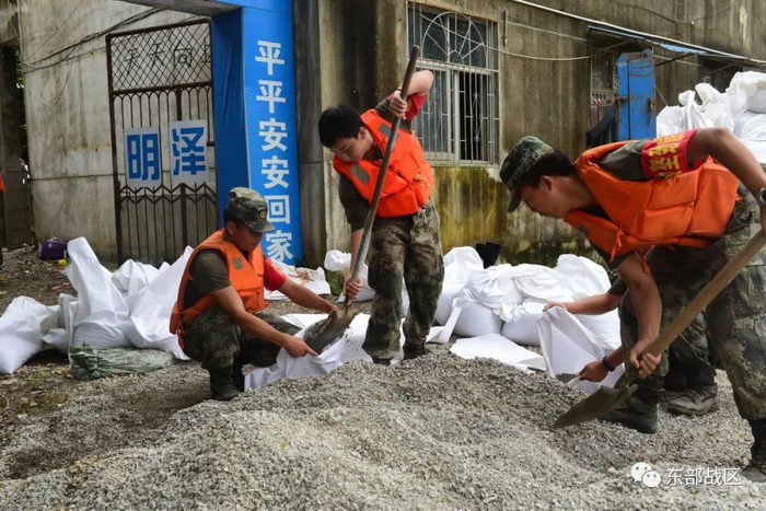 ▲7月16日，东部战区陆军第71集团军“攻坚劲旅”退伍老兵王迎港与战友们在安徽望江望江县华阳镇磨盘村加固堤坝。