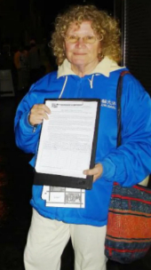 ▲柯琳·安·梅顶着澳大利亚冬天的寒风冷雨，替“法轮功”邪教做宣传