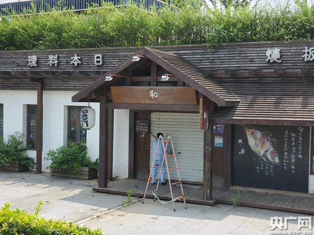 工作人员正在拆除门帘标志。中央广播电视总台央广记者 任梦岩 摄