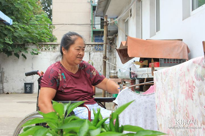 　　王胜芹正在晾晒衣服。在康复村，晾衣绳的高度是经过精确测量的，体现着人性化。长城新媒体记者 冯立华 摄