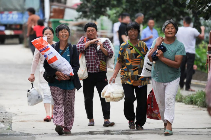 　　7月27日，安徽淮南张王村，村民外出采购食物后返村。7月20日，为保淮河安澜，淮南市毛集实验区董峰湖扒口泄洪。摄影/本刊记者 张娅子