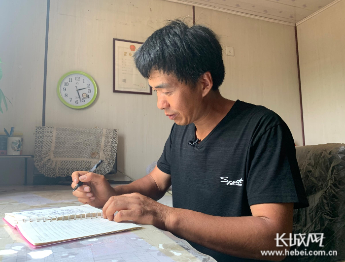 　李山峰在整理账本。刘杨 摄