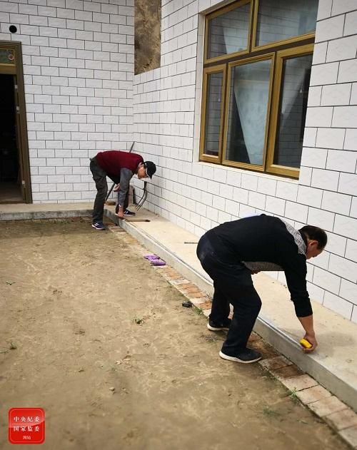 甘肃省整改办干部在庆阳市华池县王咀子乡银坪村测算贫困户危房改造面积。