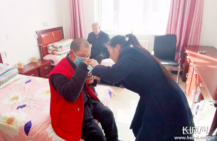 席卫琴耐心教老人正确佩戴口罩。资料图片