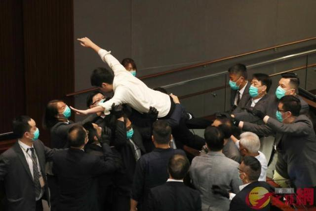 许智峰在议员台上“蝠鼠式”慢动作扑向保安堆 图源：香港《文汇报》