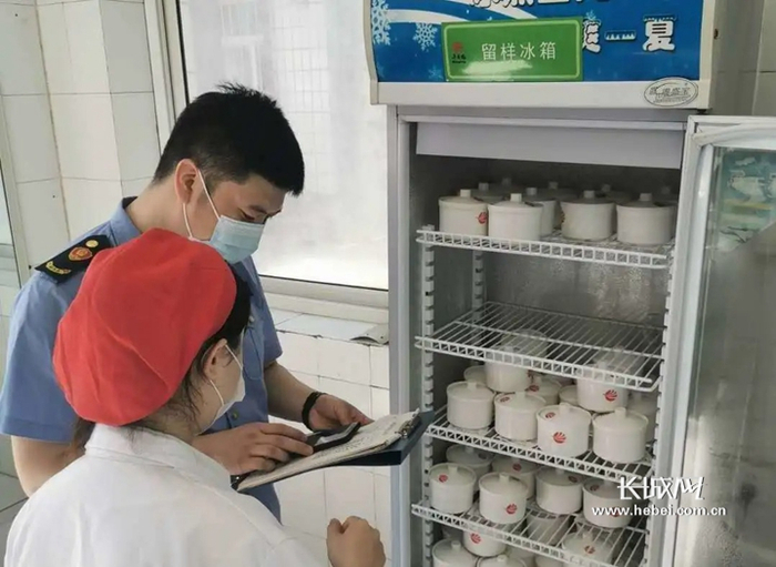 保定市市场监管局工作人员正在对食品信息进行登记核查。