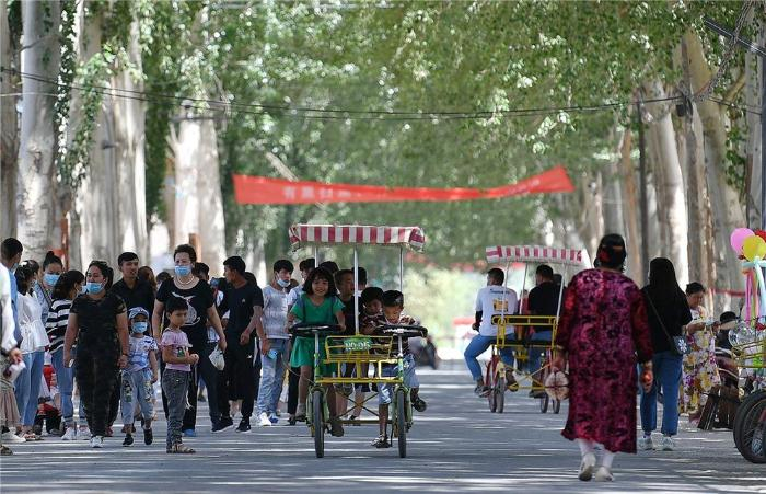 图为米夏镇樱桃园内，采摘游带动旅游热，游人如织   邹懿摄