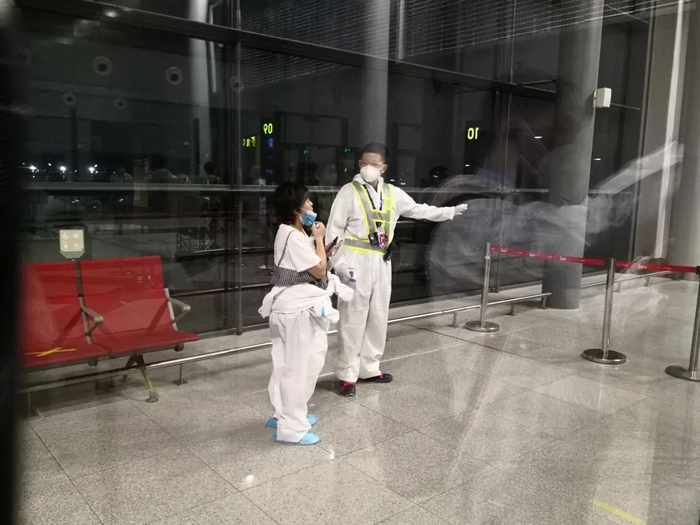 ↑国航工作人员正在引导乘客再度登机。张保 摄