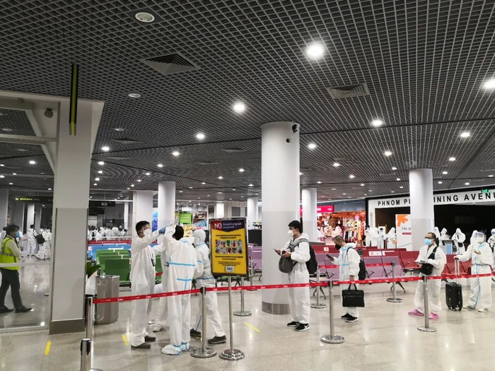 ↑“全副武装”的乘客们正在排队办理手续。张保 摄