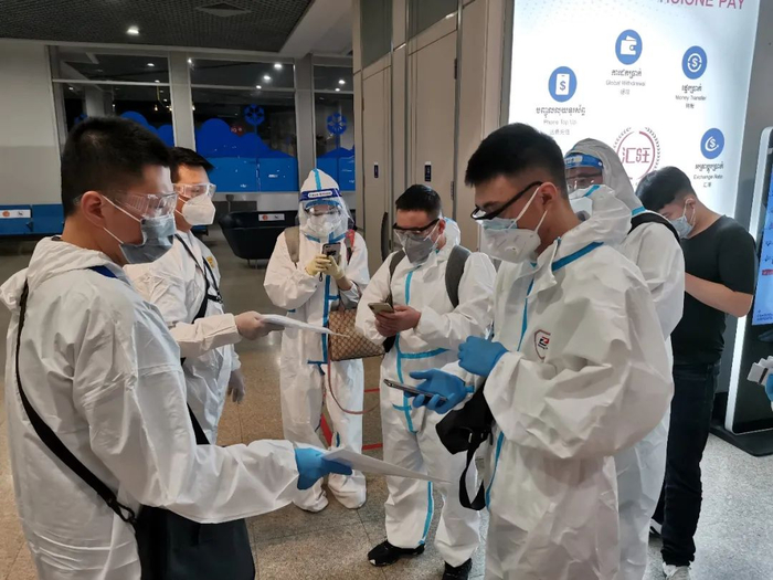 ↑国航工作人员正在引导乘客登记入境信息。张保 摄