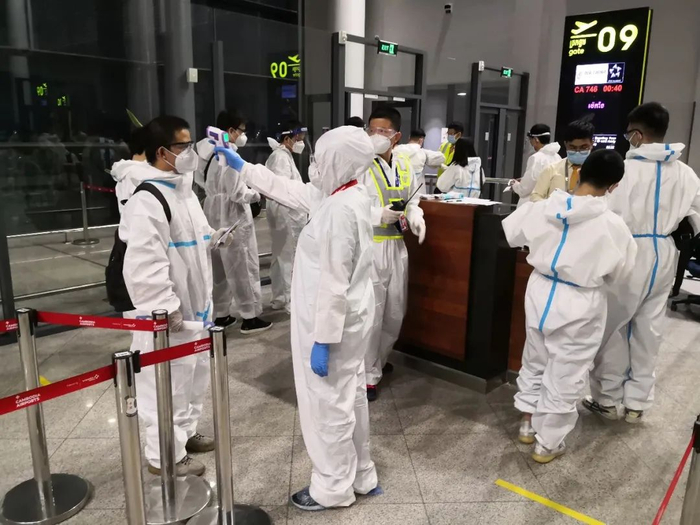 ↑国航工作人员正在登机口测温。张保  摄