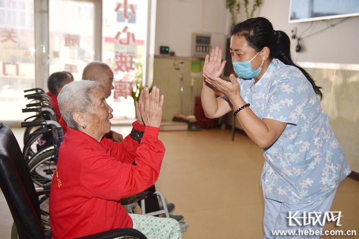 护工与老人一起互动做游戏。潘志方 供图