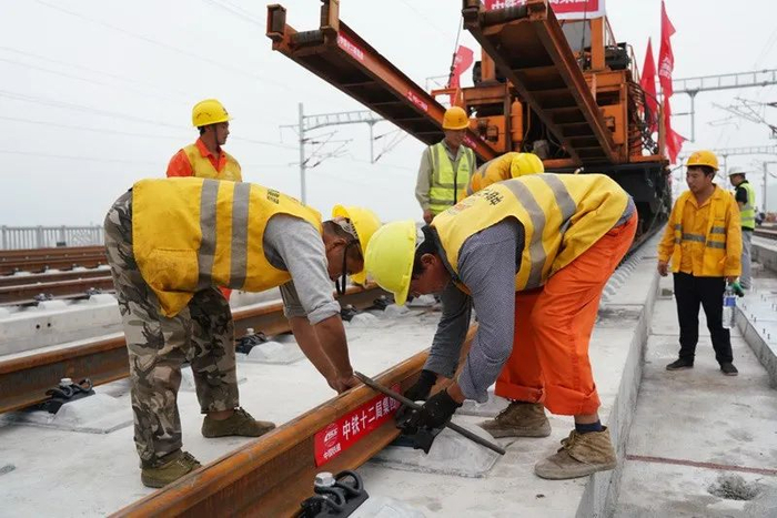 ▲8月17日，中铁十二局工人在进行铺轨作业