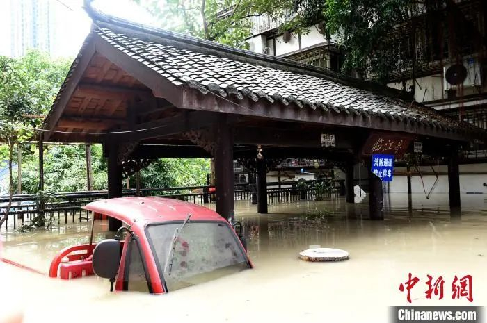 图为一辆三轮摩托被淹没在洪水中。　周毅 摄
