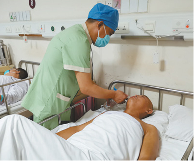 健康照护师赵朝刚在病房照护患者。　　本报记者 申少铁摄