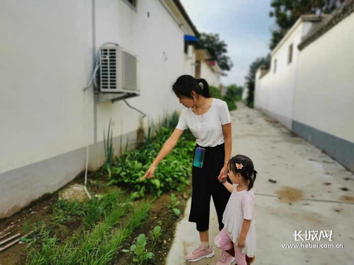 王朋雪向记者介绍家门口的小菜地。长城网记者 许艳艳 摄