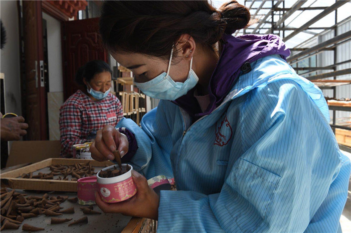 图为村民正在包装药香