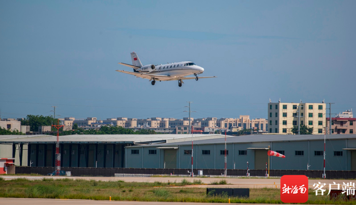 校飞飞机在美兰机场二期跑道上空进行低空通场飞行。记者 刘洋 摄