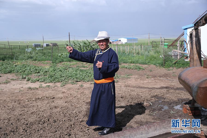 图为其日麦拉图在介绍自家牲畜牧养情况。新华网记者焦鹏摄