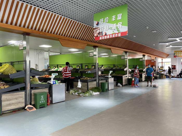 ↑市场内，摊贩按照划片分列走廊两边