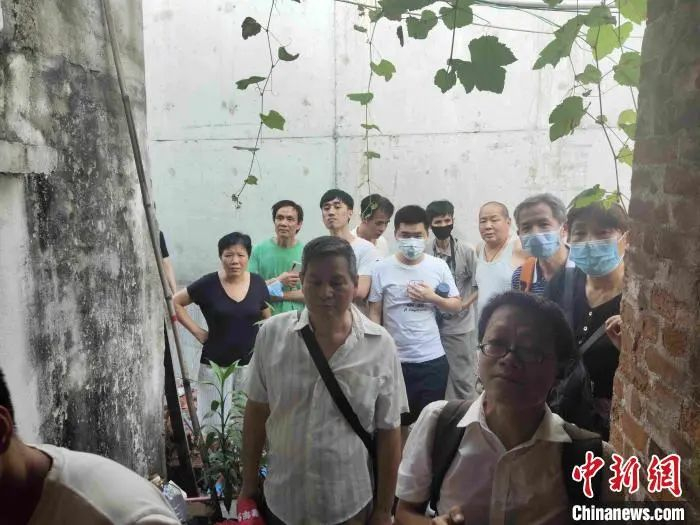 到梁女士家中围观的人越来越多。　姬东 摄