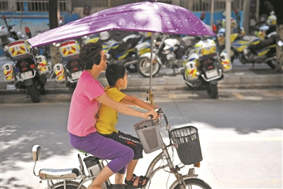  市民不带头盔骑电动车载儿童上路。广州日报全媒体记者杨耀烨 摄