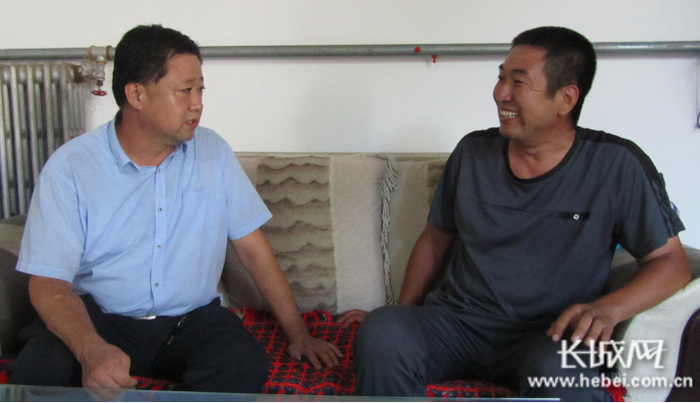 在巨鹿县洪水口村，李立飞（左）和防贫对象高建英进行交流。长城网记者 郭庆敏 摄