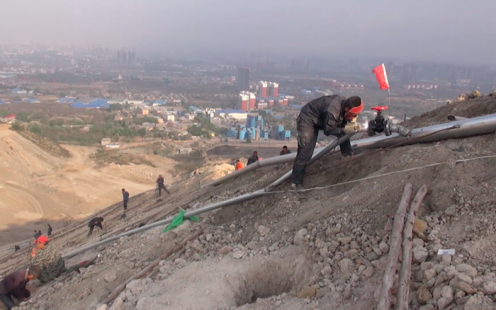 施工人员正在山上铺设管道