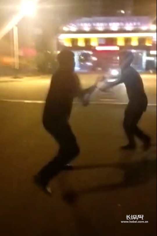 张斌与持刀男子周旋。围观群众拍摄视频截图