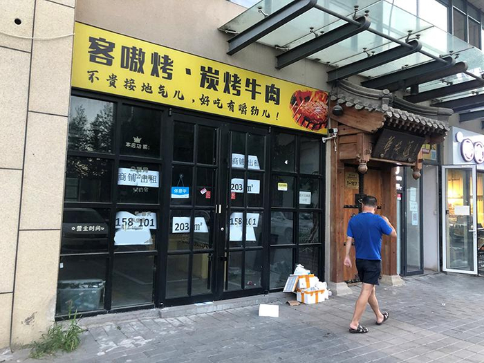 在良乡大学城附近的一条商业街上，一些店铺已经关门，并张贴上了招租的海报。 陆肖肖摄