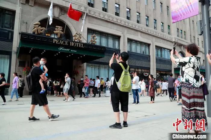 游客在和平饭店门前拍照留念。汤彦俊 摄