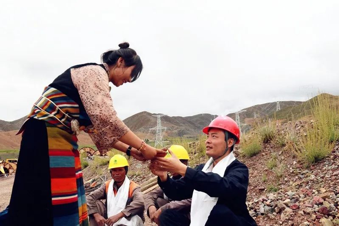 ▲7月25日，阿里电力联网工程（包2标段）贯通，当地藏族同胞送来酥油茶、献上哈达表示感谢。