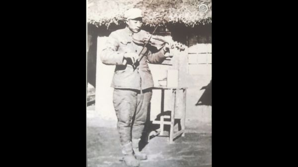 在战斗间隙，程茂友为战友拉小提琴。（受访者供图）