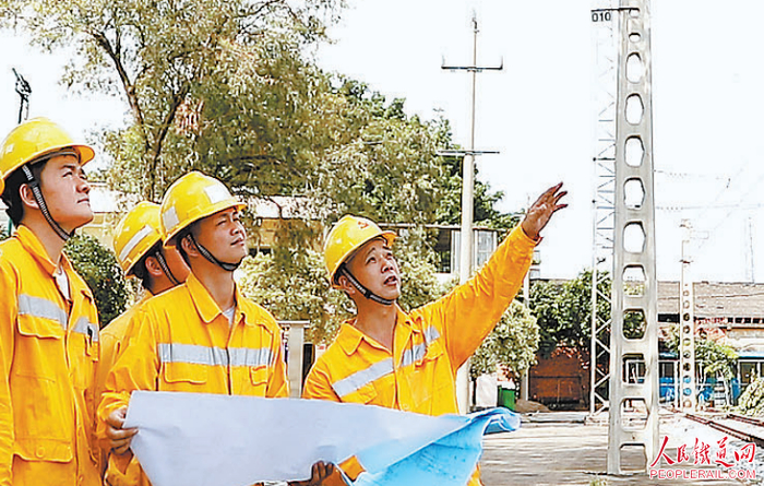 姜新松（右一）在练兵场指导职工。 廖梓锋 摄