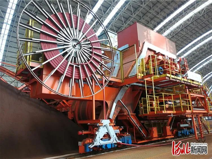 中国五矿曹妃甸国际矿石交易中心项目精混成品堆场A-1区，十余米高的混匀取料机正在矿粉料堆上作业。河北日报记者赵泽众摄