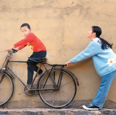 游客与创意壁画《骑单车的二猛》合影留念。　　五合乡文化站供图