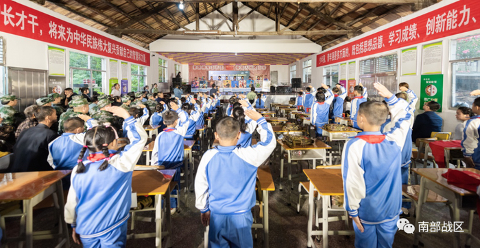 ▲学生代手捧全军十大英模挂像走上讲台宣讲英模事迹