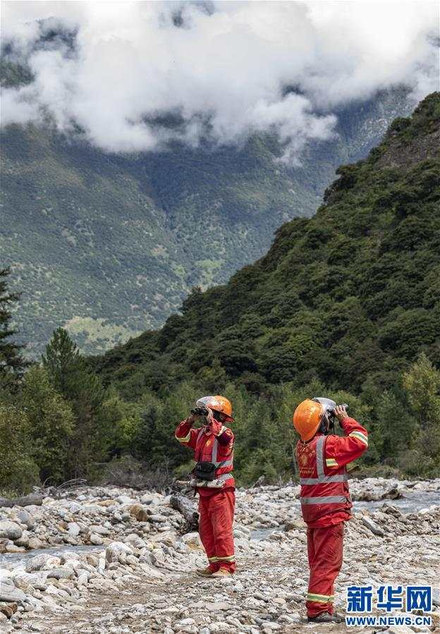 　　 护林员白玛次仁（右）和索朗次仁（左）使用望远镜观察远方山林情况（9月14日摄）。新华社记者 孙非 摄