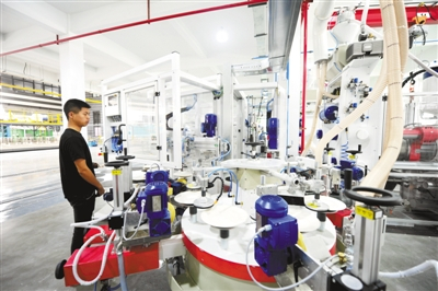 　　图为工人在景德镇陶瓷智造工坊生产车间内的自动施釉流水线上作业。