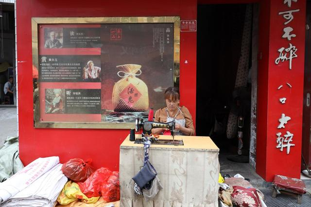 　　图说：在浦市古镇上，世俗的日常生活在悄然继续，摄影师的镜头捕捉到了一位专心致志的裁缝。摄影师：王毅楠