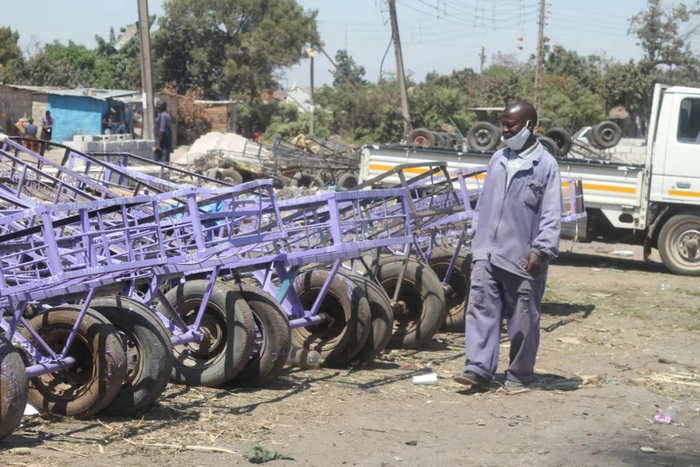 ▲9月9日，在津巴布韦首都哈拉雷南郊的姆巴雷，车行老板卡特雷拉检查他的手推车。新华社发（塔法拉·穆瓜拉 摄）