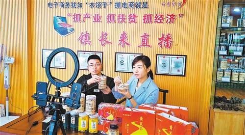 哈达铺镇药乡农民专业合作社联合社负责电商运营的扈鹏泰（左）正在直播中推销黄芪茶。经济日报 记者 赵梅 摄 